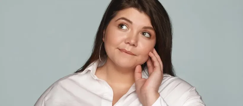 portrait belle jeune employee surpoids portant chemise blanche boucles oreilles rondes regardant mordant levre ayant expression pensive pensant que aliments sains mangent pour dejeuner jpg